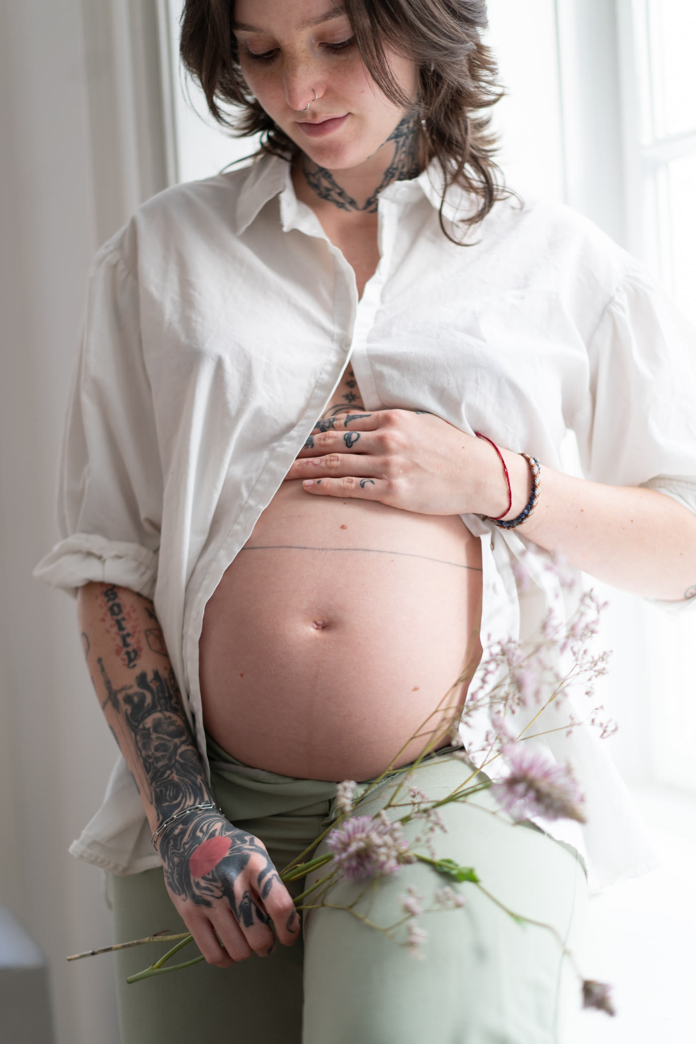 Schwangere Frau, die Hand auf ihrem Bauch, blickt auf ihr Baby im Bauch